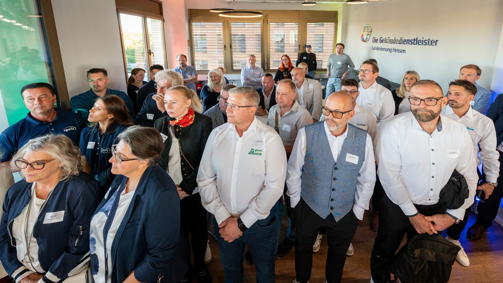 Gäste im Foyer vor der Wand „Die Gebäudedienstleister Landesinnung Hessen“