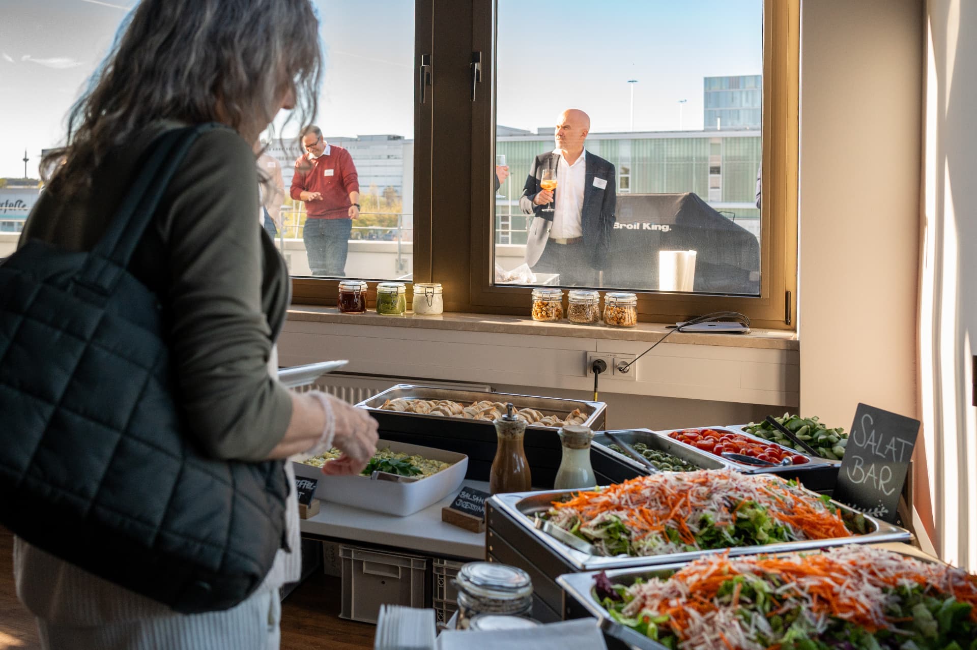 Buffet mit Salatbar, im Hintergrund die Dachterrasse mit Blick über Frankfurt