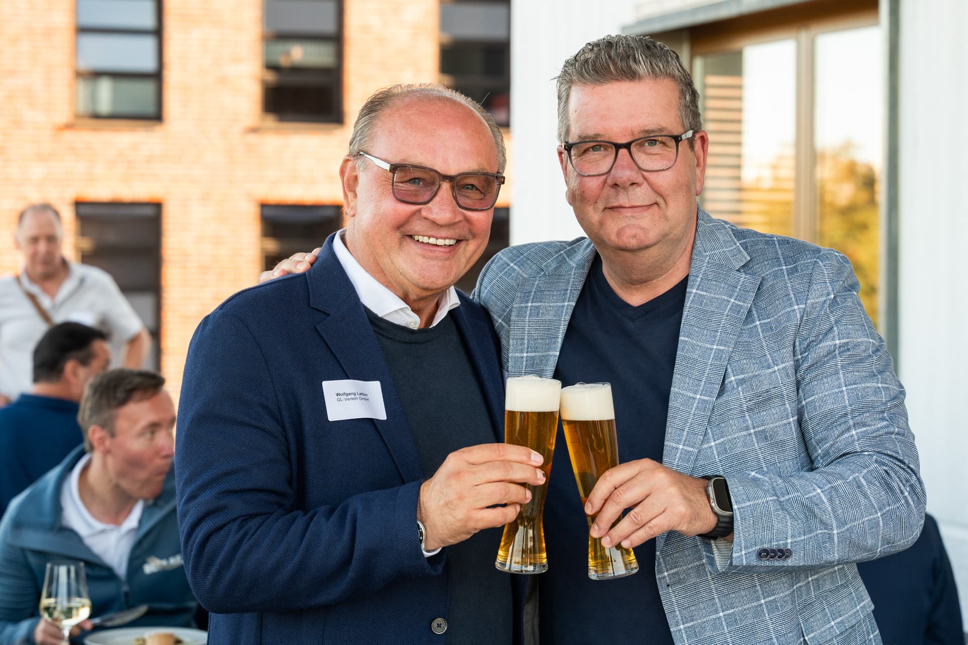 Zwei Gäste stoßen mit Bier an