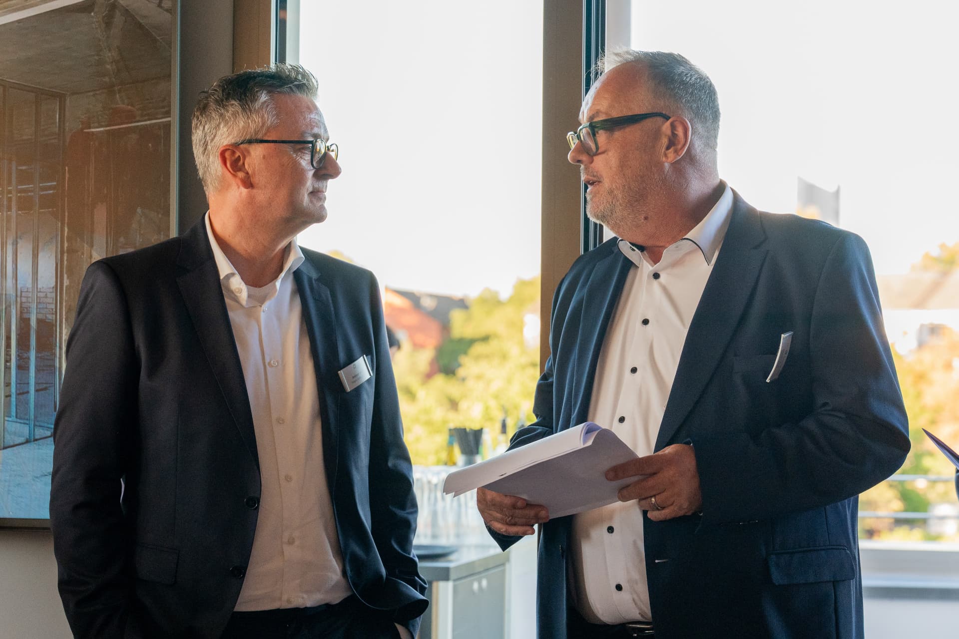 Zwei Gäste im Gespräch mit Unterlagen